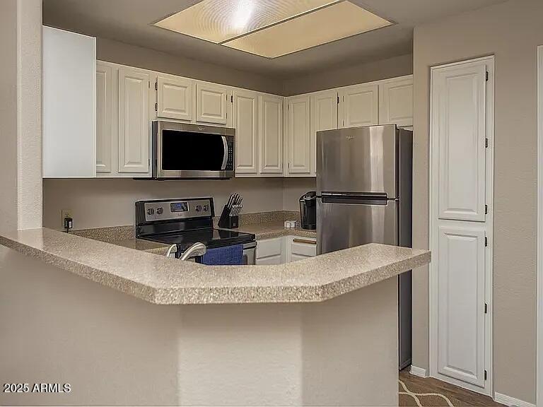 11375 East Sahuaro Drive, Unit 2041 Scottsdale, AZ 85259 - Photo 5 of 17 a kitchen with stainless steel appliances granite countertop a refrigerator a stove a microwave and cabinets