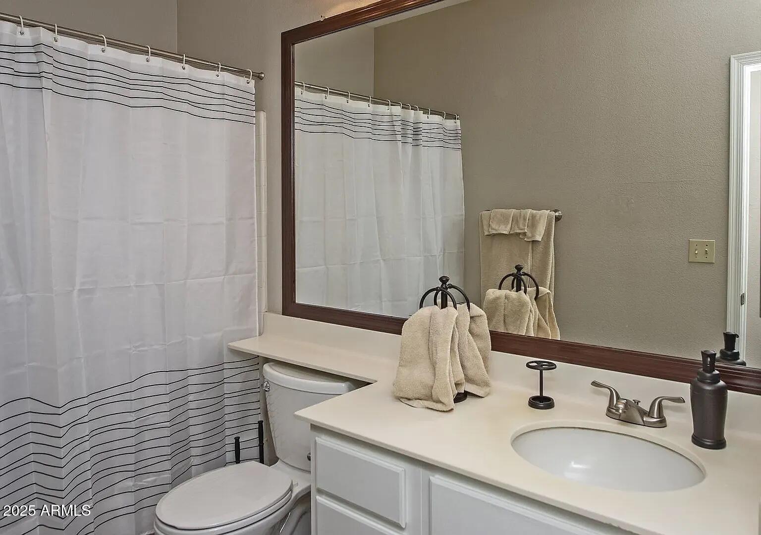 11375 East Sahuaro Drive, Unit 2041 Scottsdale, AZ 85259 - Photo 10 of 17 a bathroom with a sink vanity mirror and toilet