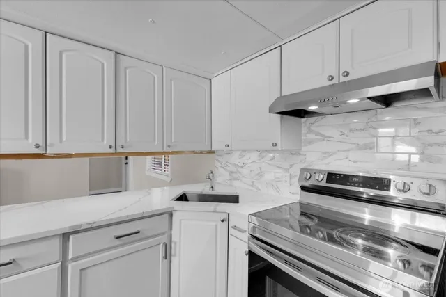 a kitchen with white cabinets and appliances