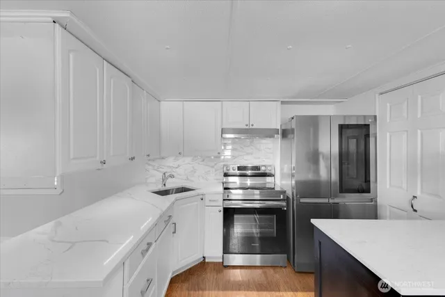 a kitchen with stainless steel appliances a sink stove and refrigerator