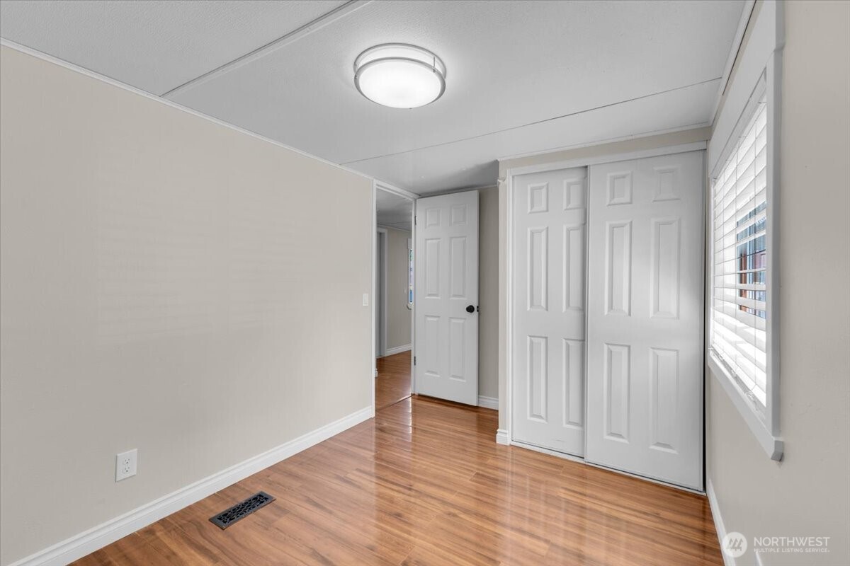7614 Northeast Bothell Way, Unit 11 Kenmore, WA 98028 - Photo 20 of 26 a view of an empty room with wooden floor and a window