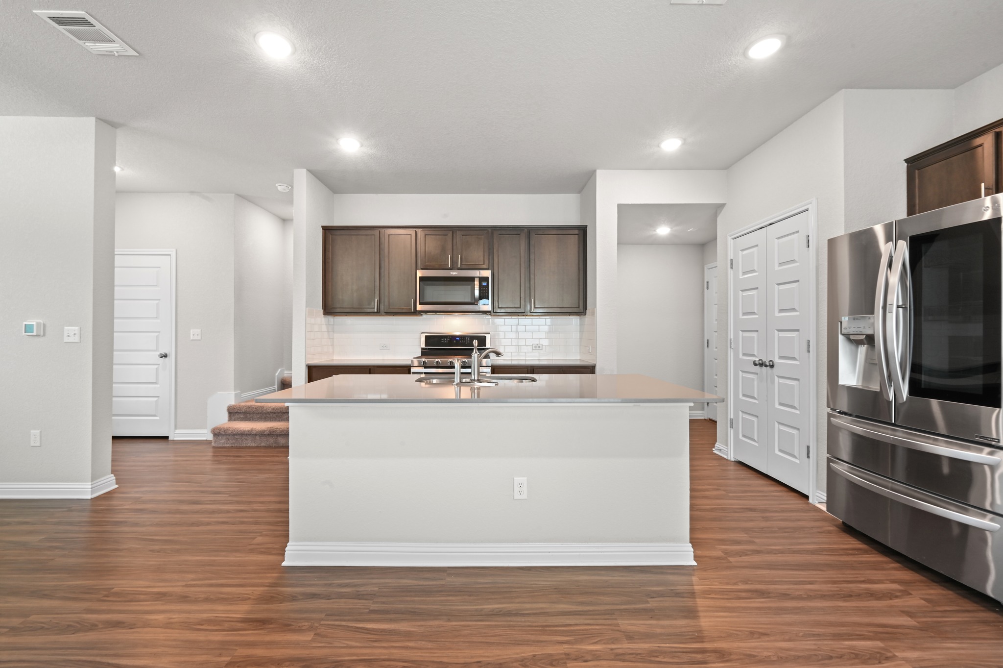 8201 Frida Bend Austin, TX 78744 - Photo 15 of 29 A well-appointed kitchen features rich cabinetry, stainless steel appliances, and a central island.