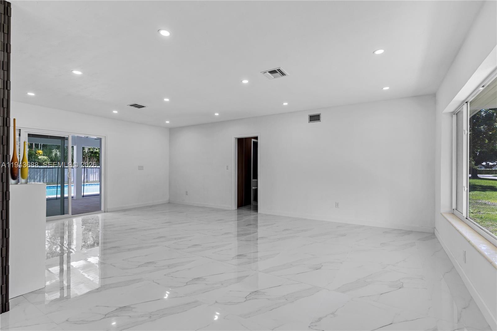 12525 Southwest 68th Court Pinecrest, FL 33156 - Photo 13 of 46 a view of an empty room with wooden floor and a window