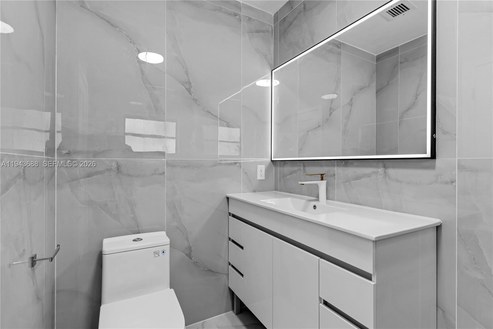 12525 Southwest 68th Court Pinecrest, FL 33156 - Photo 20 of 46 a bathroom with a sink a toilet and a mirror