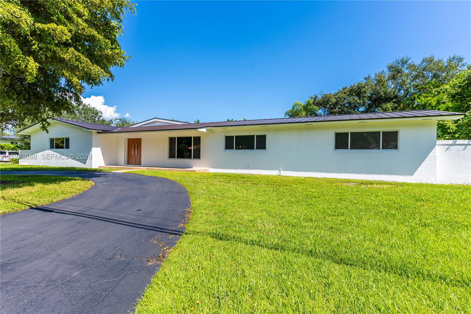 12525 Southwest 68th Court Pinecrest, FL 33156 - Photo 2 of 46 a front view of house with yard and swimming pool