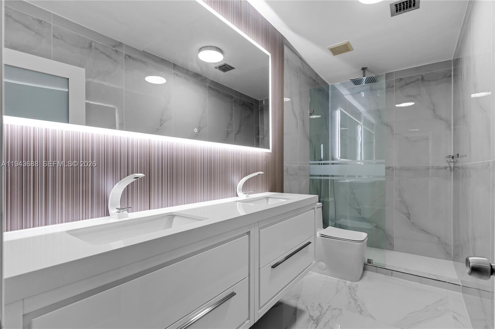 12525 Southwest 68th Court Pinecrest, FL 33156 - Photo 29 of 46 a bathroom with a toilet sink and mirror