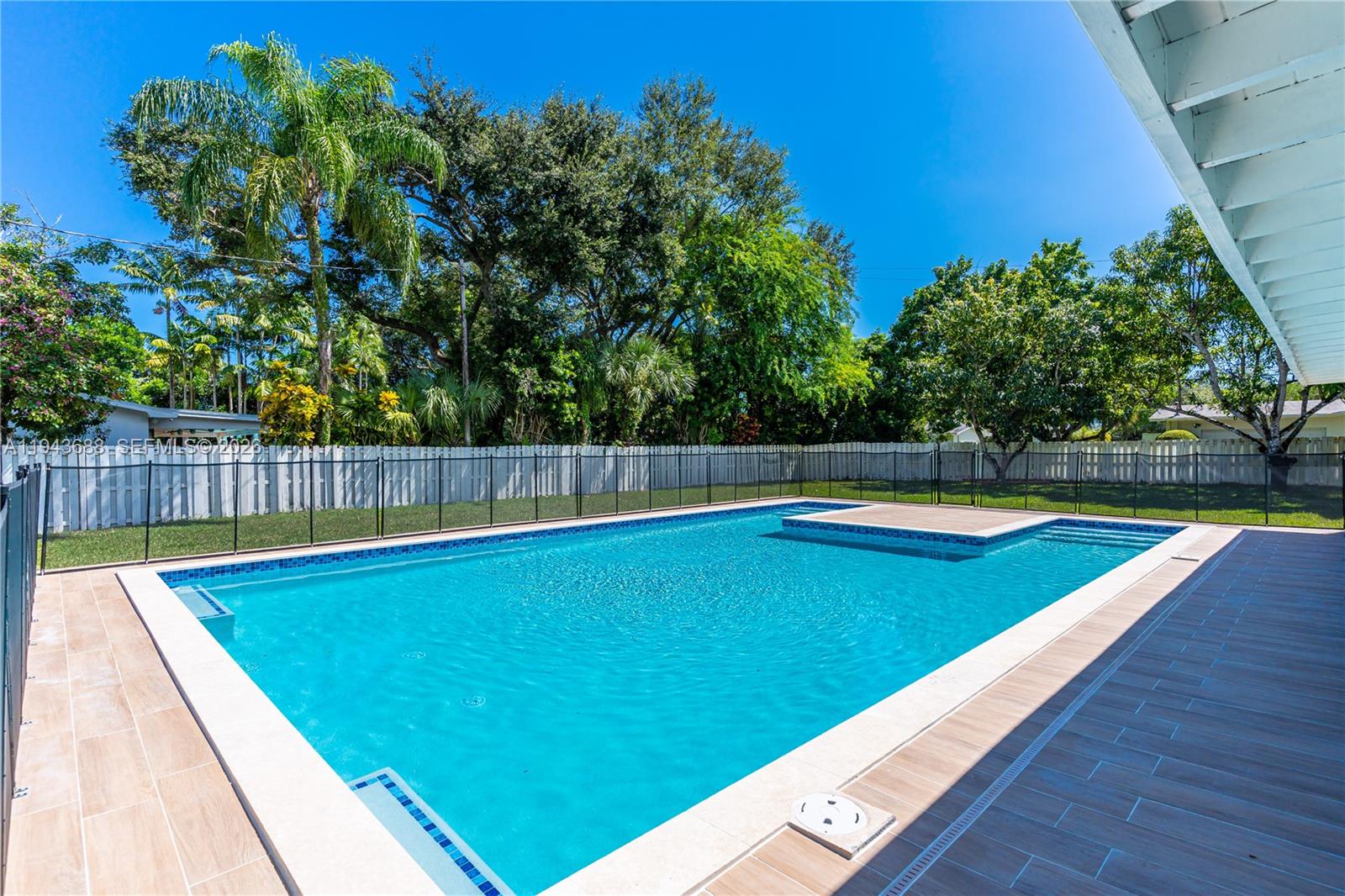 12525 Southwest 68th Court Pinecrest, FL 33156 - Photo 37 of 46 a view of a backyard with swimming pool and wooden fence