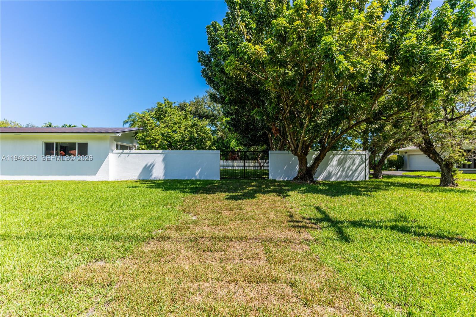 12525 Southwest 68th Court Pinecrest, FL 33156 - Photo 40 of 46 a backyard of a house with lots of green space