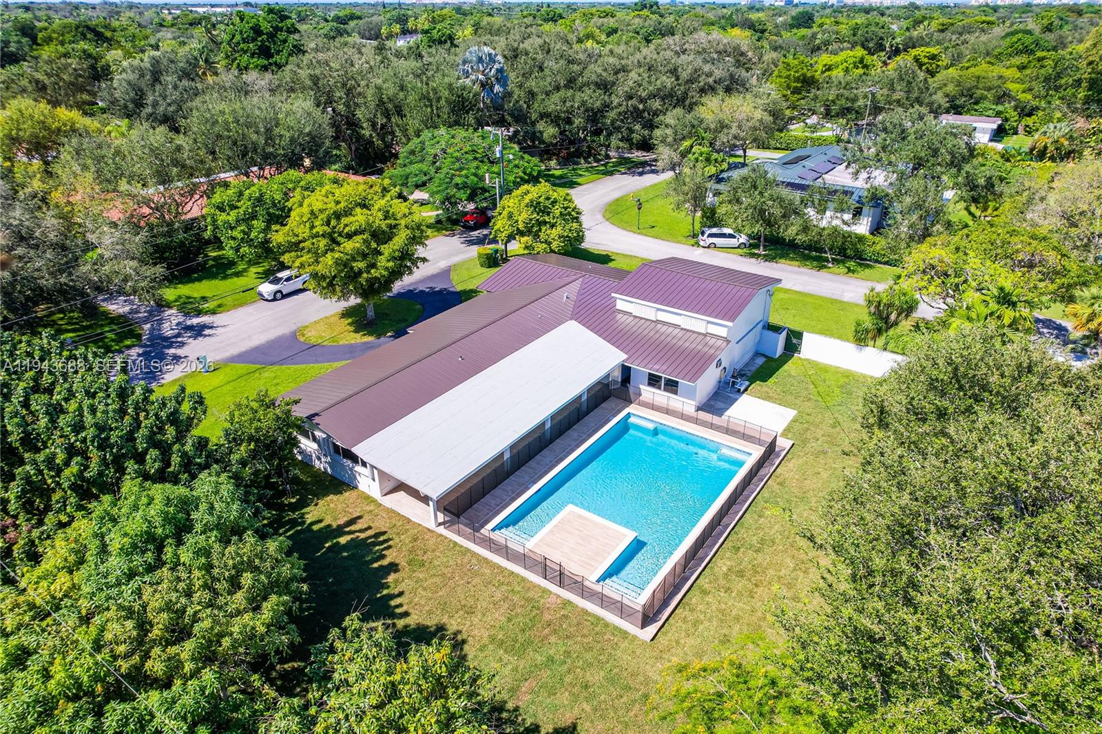 12525 Southwest 68th Court Pinecrest, FL 33156 - Photo 4 of 46 an aerial view of a pool patio lake and outdoor seating