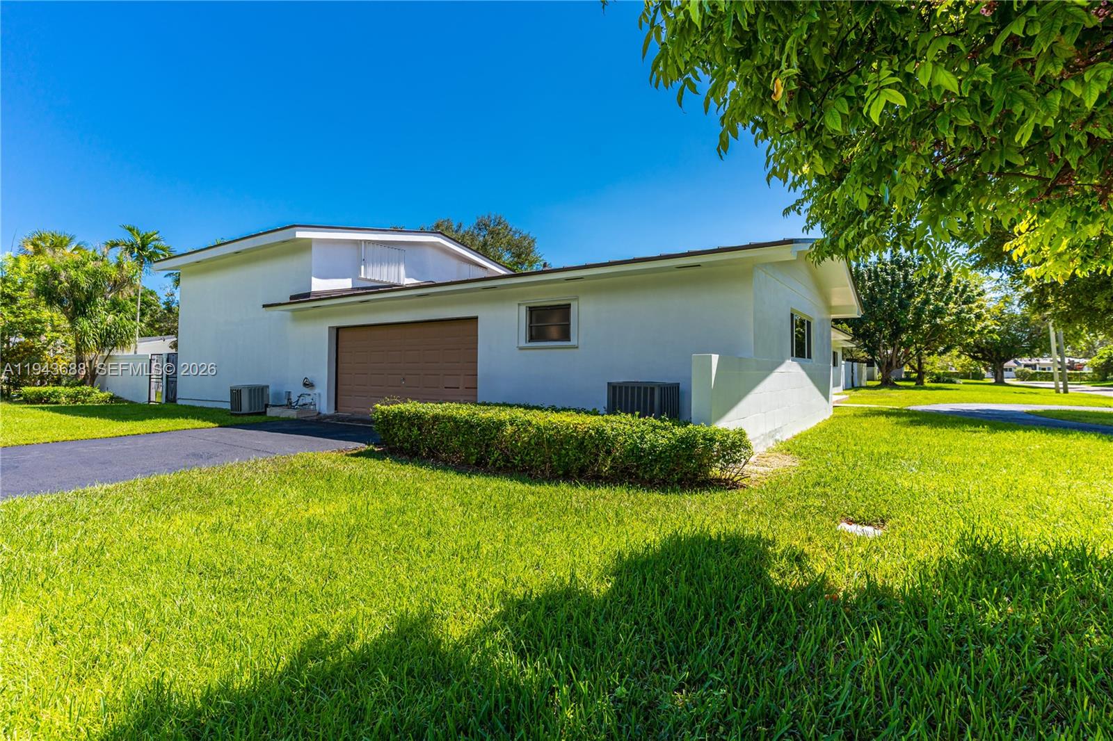 12525 Southwest 68th Court Pinecrest, FL 33156 - Photo 42 of 46 a front view of house with yard and green space
