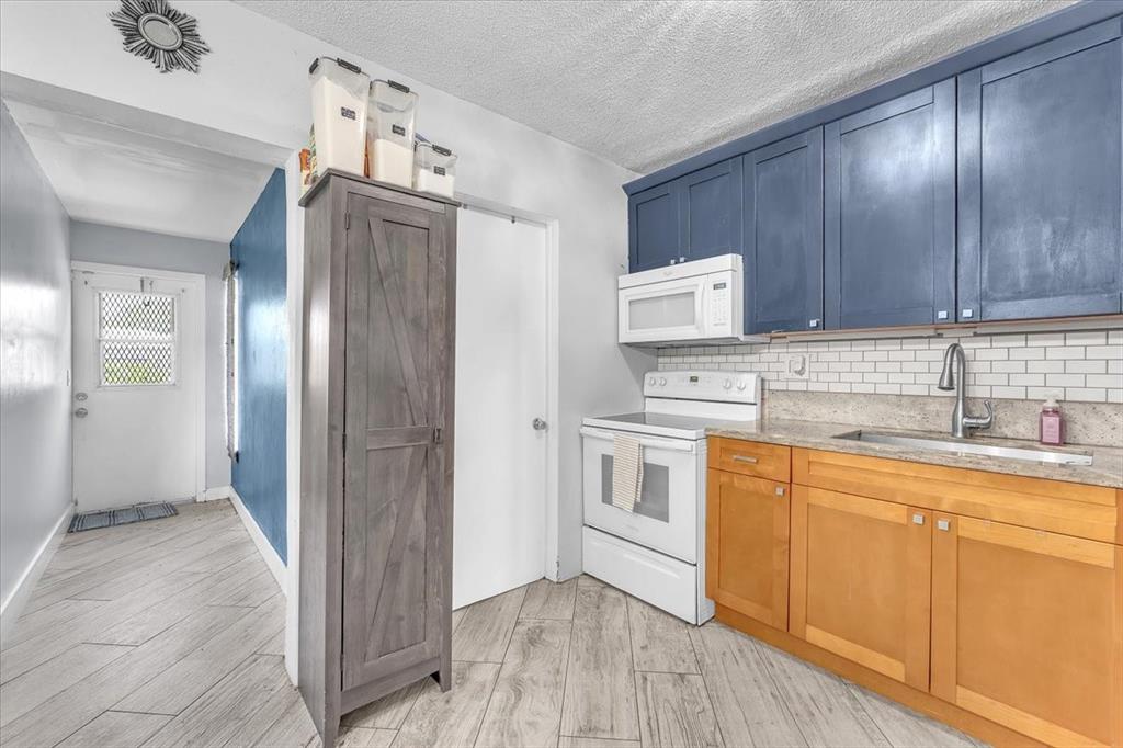 6621 Southwest 19th Street Pompano Beach, FL 33068 - Photo 8 of 16 a kitchen with granite countertop a refrigerator sink and cabinets