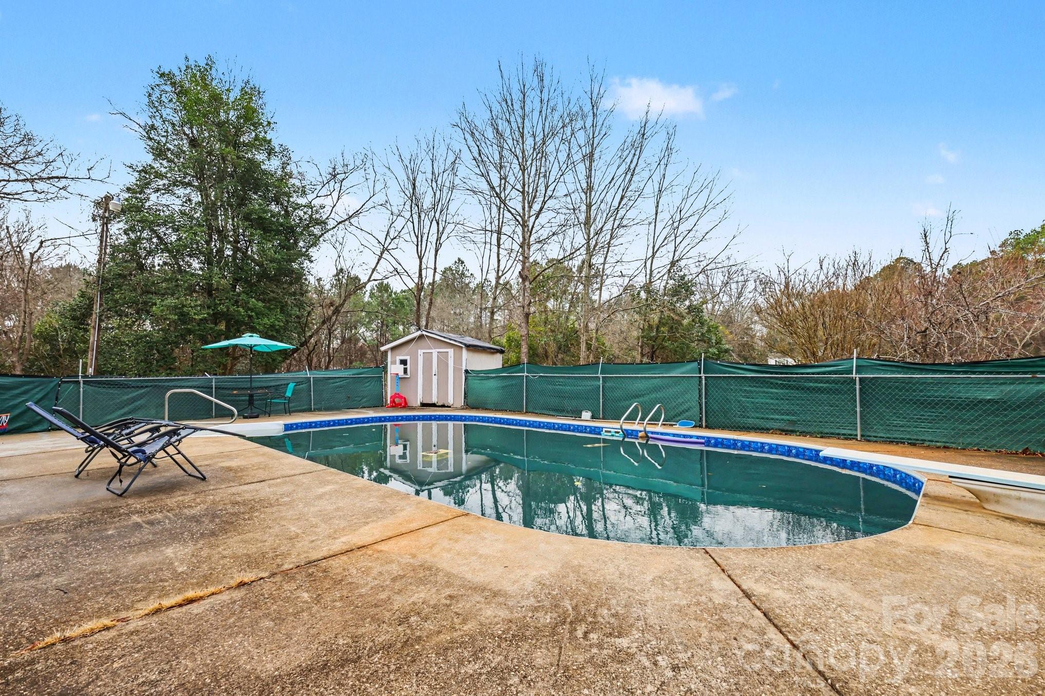 128 Paul Snipes Road Lancaster, SC 29720 - Photo 27 of 29 a view of a swimming pool with a bench and trees in the background