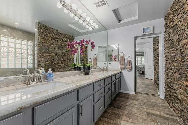 a bathroom with a double vanity sink mirror and shower