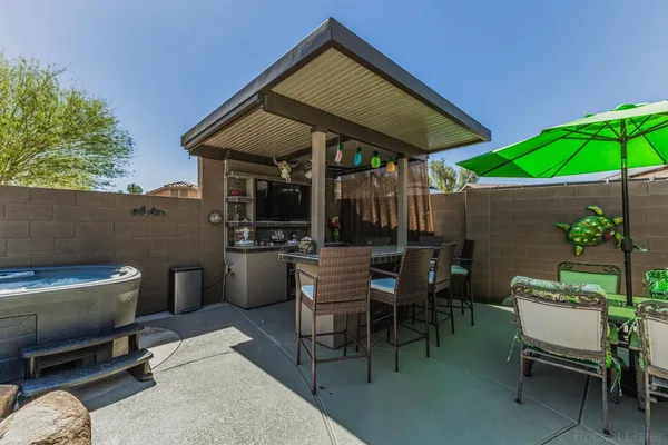 a patio with a table and chairs under an umbrella