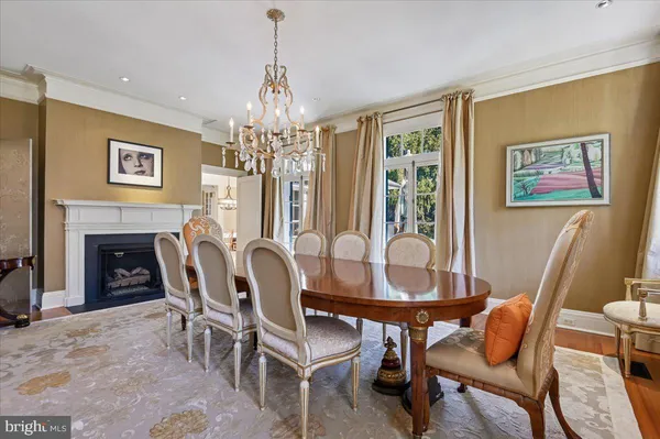 a dining room with furniture a chandelier and wooden floor