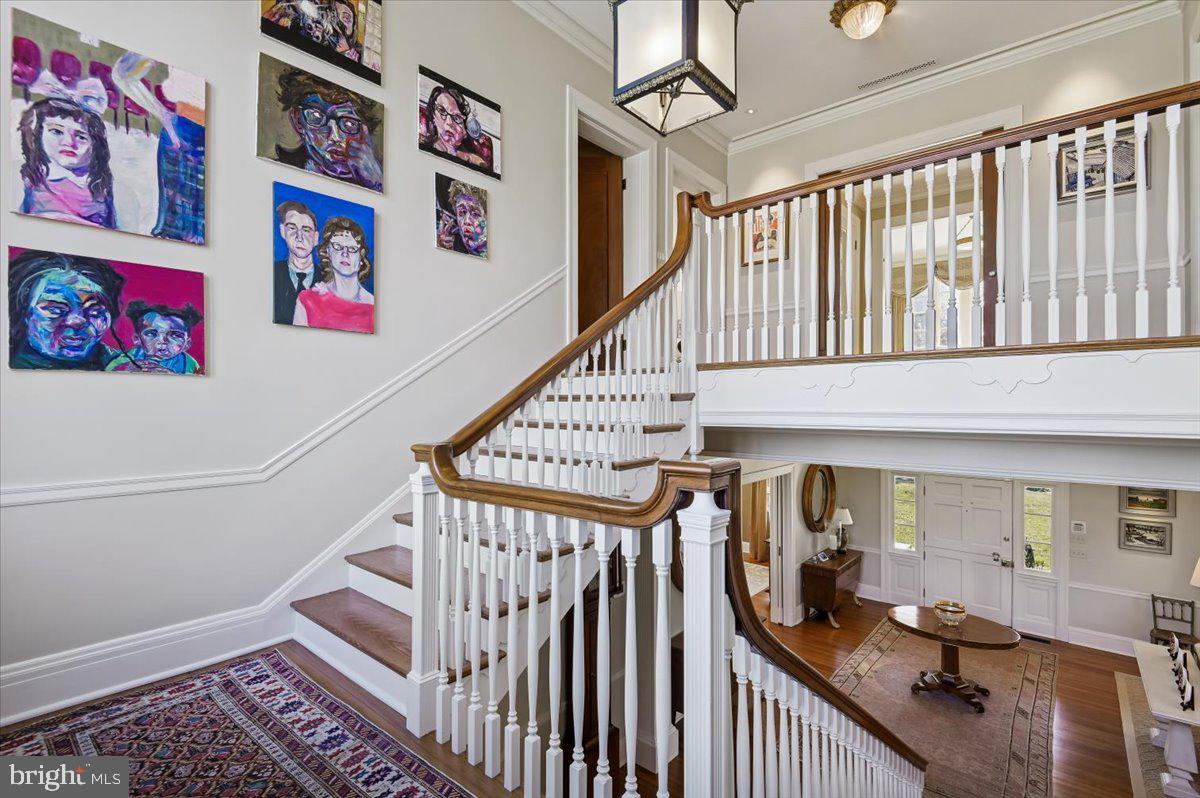 922 Rolandvue Road Baltimore, MD 21204 - Photo 35 of 89 a view of staircase with lots of frames on wall and a chandelier