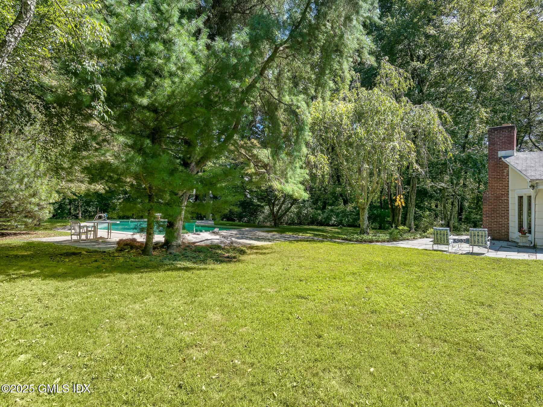 267 Riversville Road Greenwich, CT 06831 - Photo 19 of 23 a view of a swimming pool with a yard and large trees