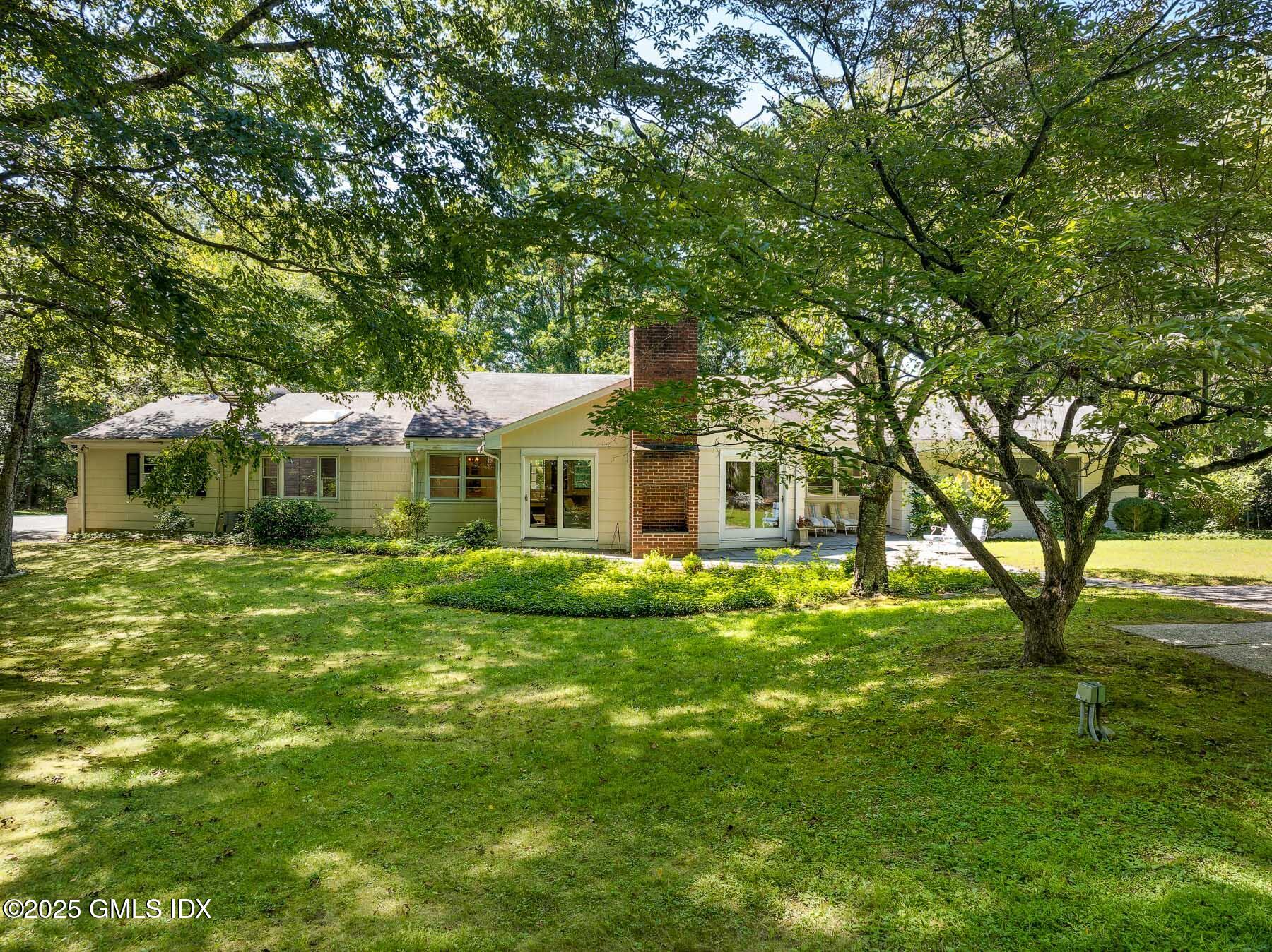 267 Riversville Road Greenwich, CT 06831 - Photo 20 of 23 a front view of a house with a garden