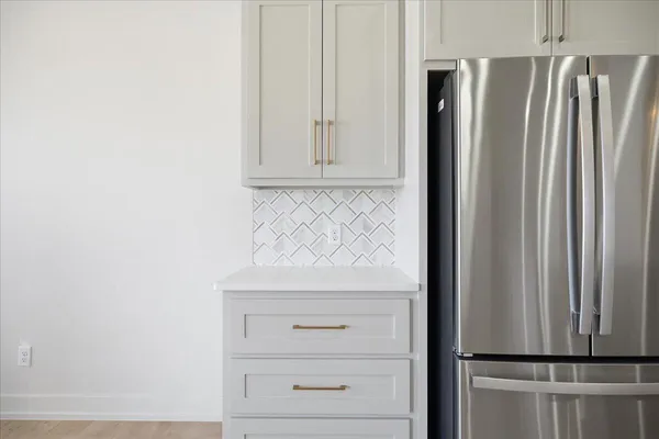 a view of kitchen with refrigerator and cabinet