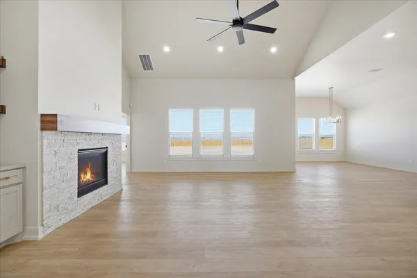 an empty room with windows and a fireplace