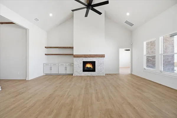 a view of an empty room with a window and fireplace