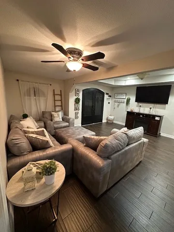 a living room with furniture a ceiling fan and a rug