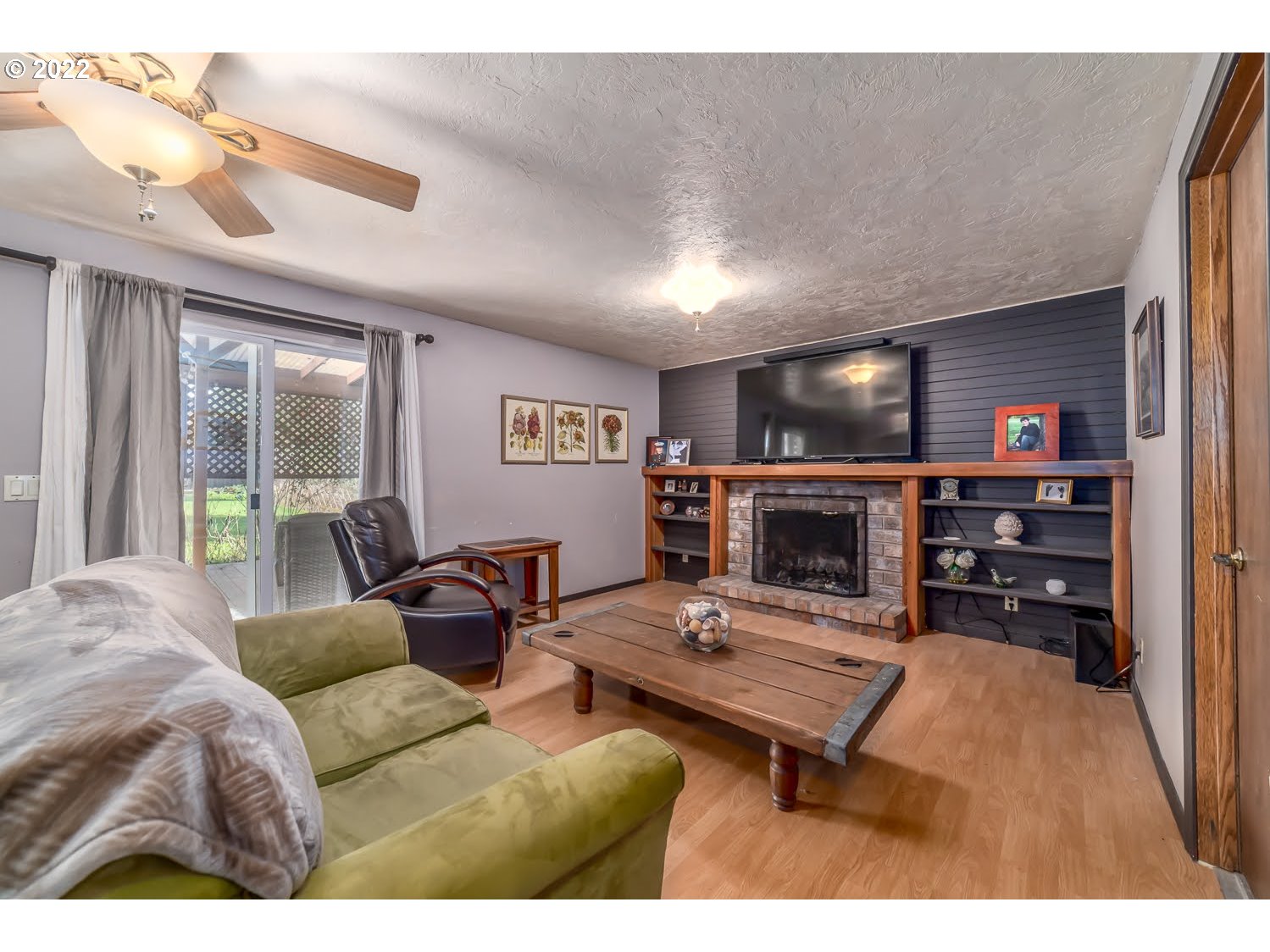 6520 E Street Springfield, OR 97478 - Photo 24 of 32 a living room with furniture a fireplace and a flat screen tv