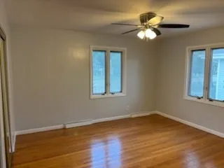 a view of wooden floor and a chandelier fan in a room