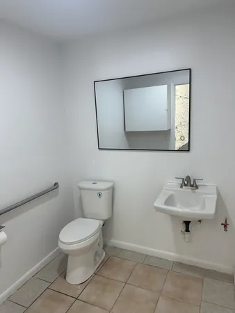 a bathroom with a toilet sink and mirror