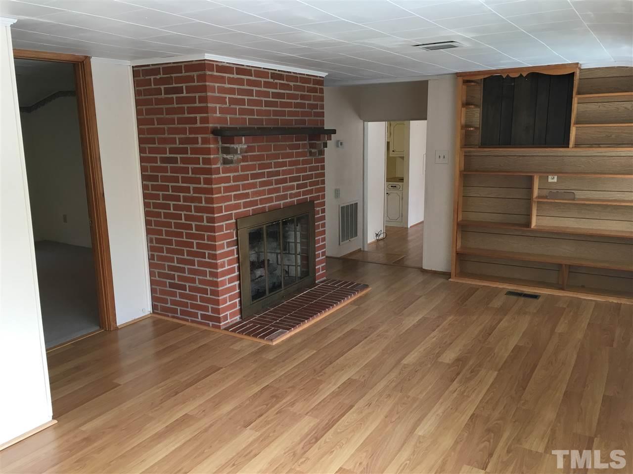 31 Service Road Roxboro, NC 27574 - Photo 6 of 18 a view of empty room with wooden floor and fireplace