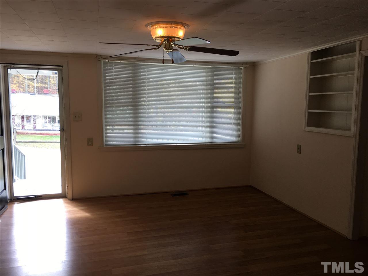 31 Service Road Roxboro, NC 27574 - Photo 8 of 18 an empty room with wooden floor and windows
