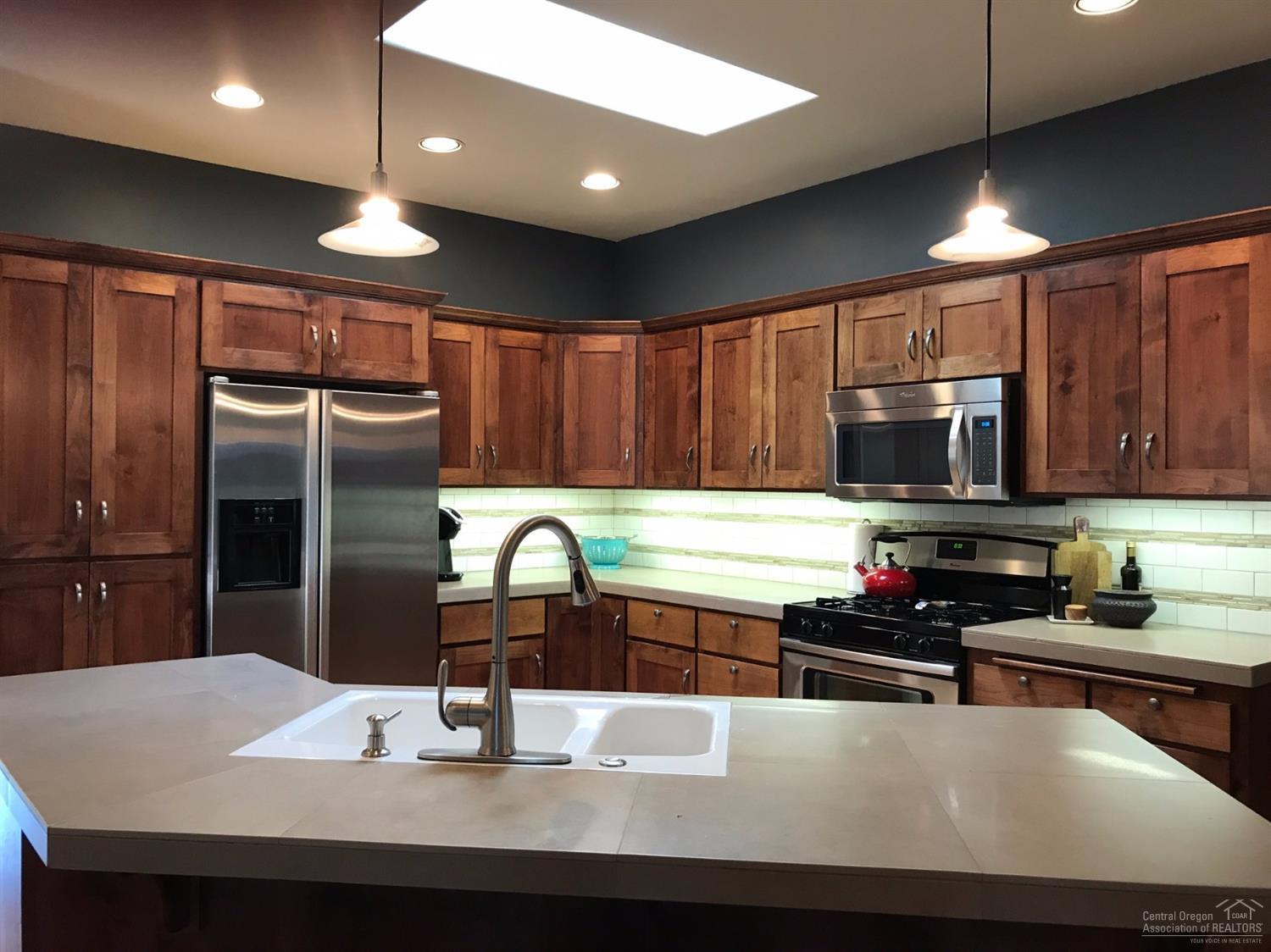 2422 Northwest Awbrey Road Bend, OR 97703 - Photo 8 of 21 a kitchen with kitchen island granite countertop a sink stainless steel appliances and cabinets