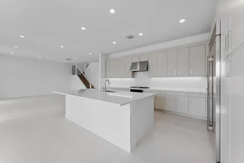 a view of empty room with wooden floor and large window