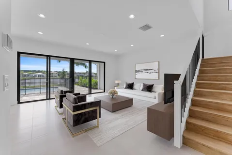 an empty room with wooden floor and staircase
