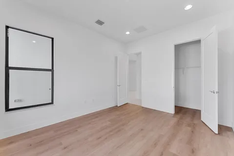 a bedroom with a bed window and dresser