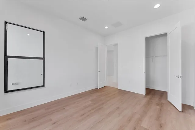 a bedroom with a bed window and dresser