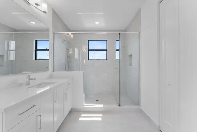 a bathroom with a bathtub shower sink vanity and toilet