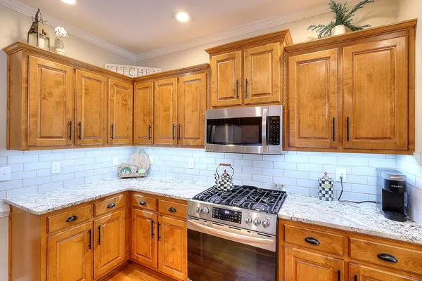 a kitchen with granite countertop stainless steel appliances a refrigerator and a sink