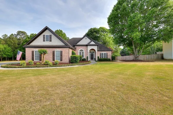 a front view of house with yard and trees around