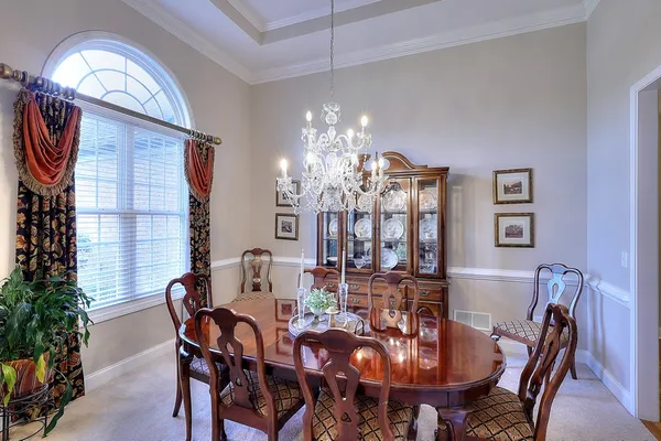 a view of a dining room with furniture a chandelier and wooden floor