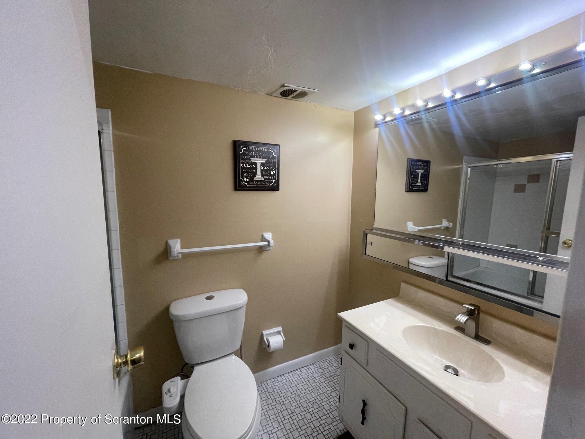 1501 Summit Pointe Scranton, PA 18508 - Photo 7 of 12 a bathroom with a toilet sink and mirror