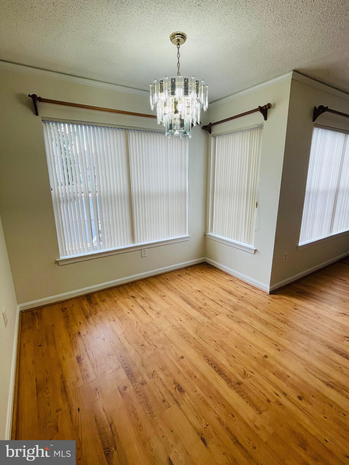 14229 Bowsprit Lane, Unit 501 Laurel, MD 20707 - Photo 4 of 19 a view of an empty room with chandelier and wooden floor