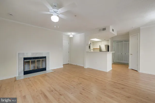 an empty room with windows and fireplace