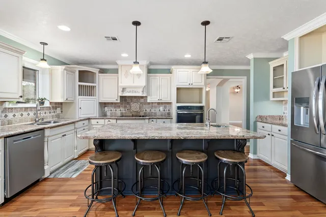 a kitchen with granite countertop a counter space stainless steel appliances and cabinets