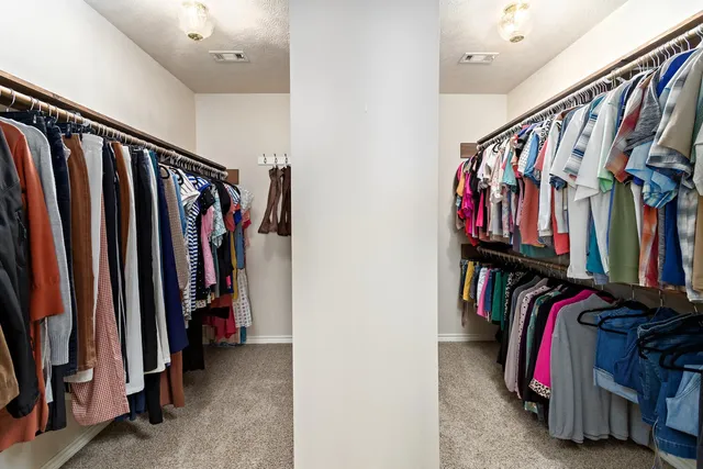 a view of walk in closet with clothes