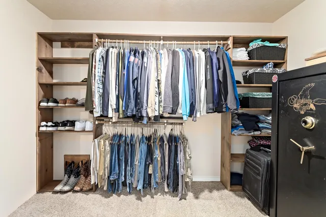 a view of walk in closet with clothes and shoes