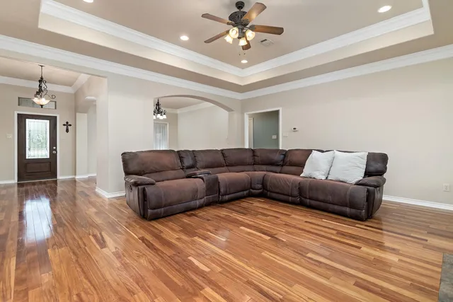 a living room with furniture and a wooden floor