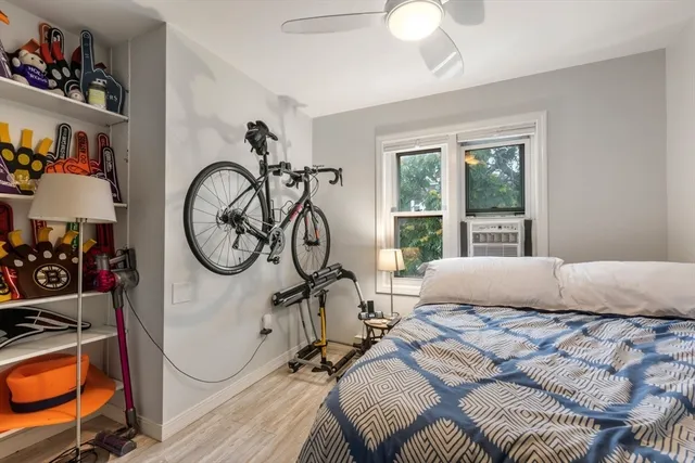 a bedroom with a bed a chandelier and a window