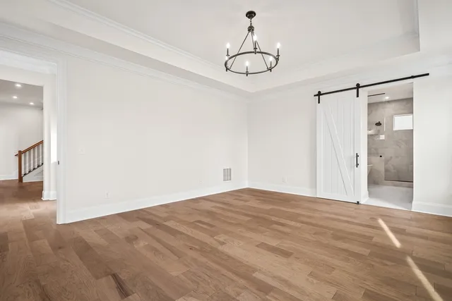 a view of an empty room with kitchen and a window