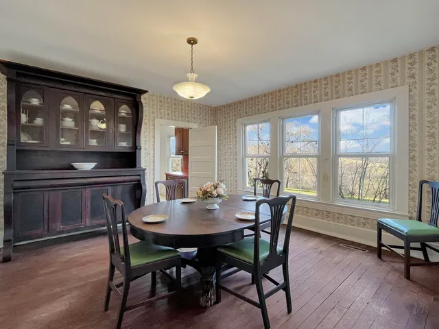 a view of a hallway with wooden floor and windows